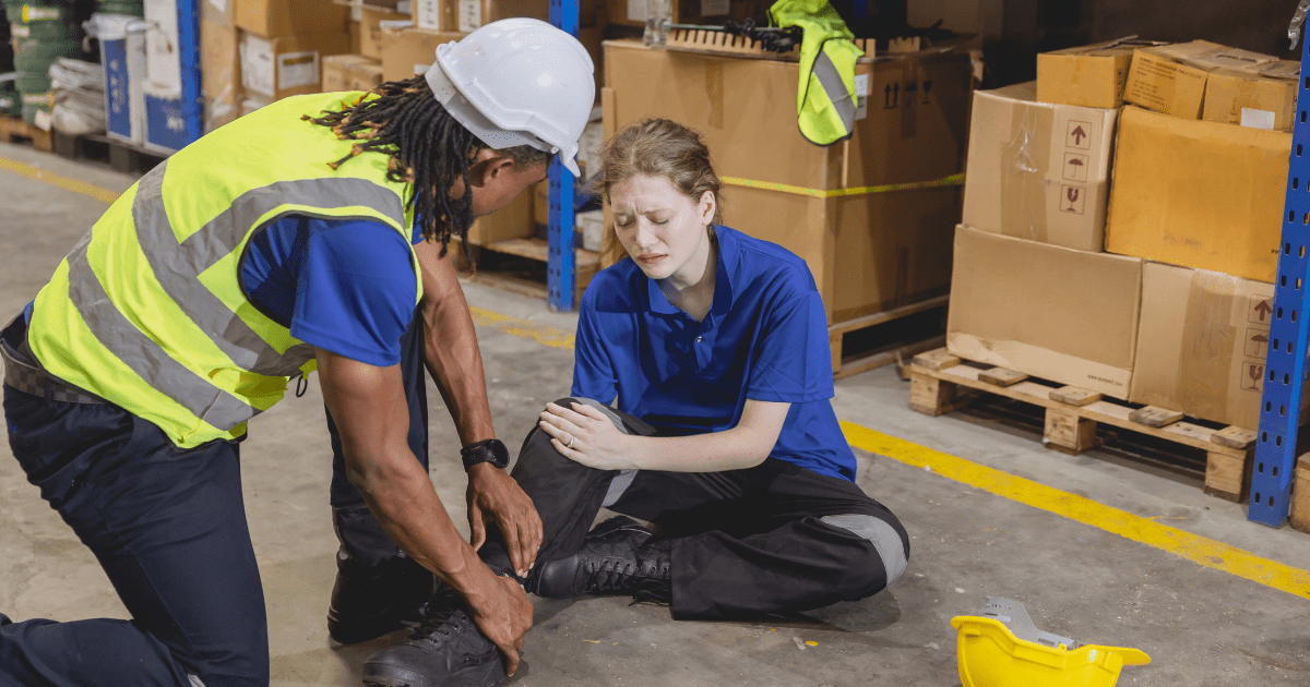 Woman on the ground at work after suffering from a slip and fall injury.