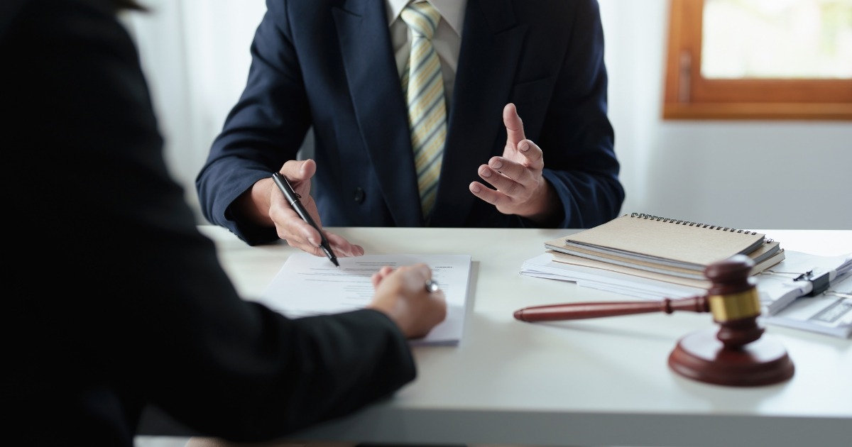 A person reviewing paperwork with an attorney, symbolizing preparation for a personal injury claim.