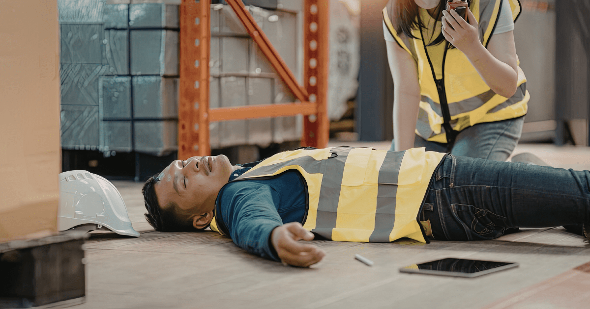 an injured warehouse worker lies on the ground
